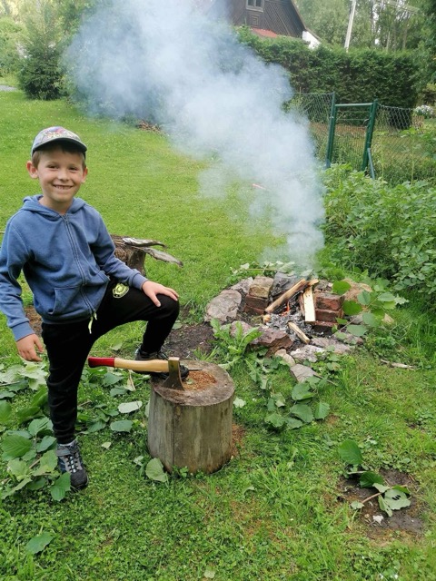 Chlapec u ohniště na zahradě